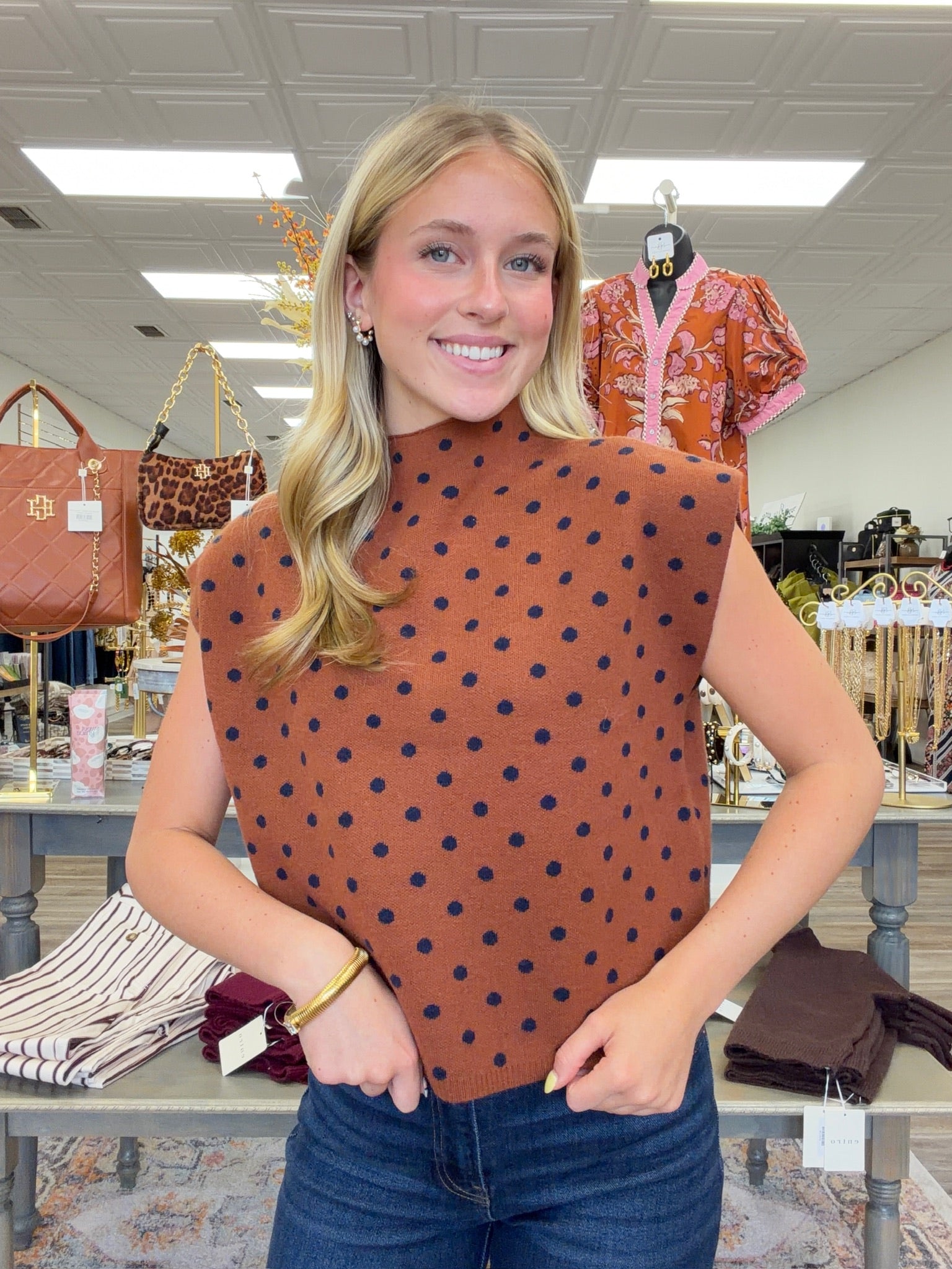 The cinnamon Spice Dot Sweater top features structured cap sleeves, navy polka dot pattern and a relaxed fit.