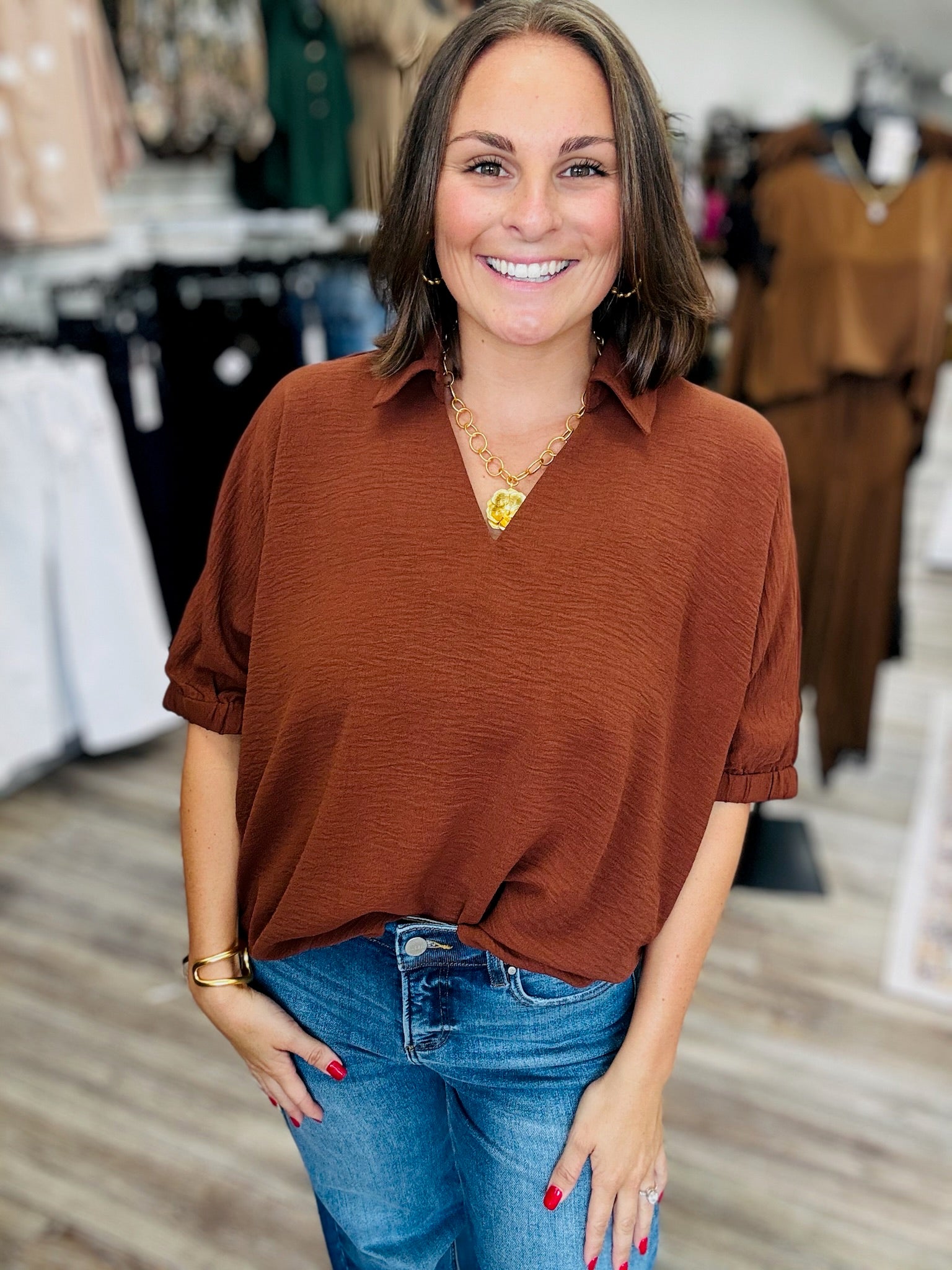 The Harper blouse - Relaxed oversized blouse in a rich rust-brown color, featuring a split V-neck collar, flowy short sleeves, and a scalloped bottom hem