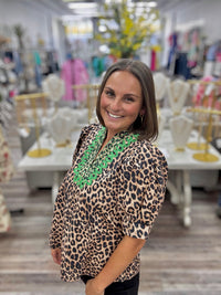 The Evangeline blouse - leopard print blouse featuring a V-neckline with bright green embroidery trim, puff sleeves, and a flowy silhouette. Entro style#T31886