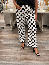 The Sadie pants - high-waisted pants featuring a bold black-and-white polka dot print with a relaxed wide-leg fit, a button-front closure and oversized front patch pockets