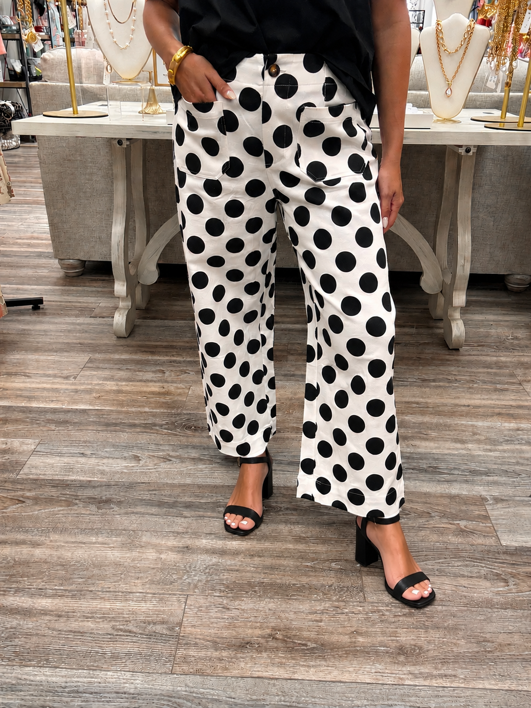 The Sadie pants - high-waisted pants featuring a bold black-and-white polka dot print with a relaxed wide-leg fit, a button-front closure and oversized front patch pockets
