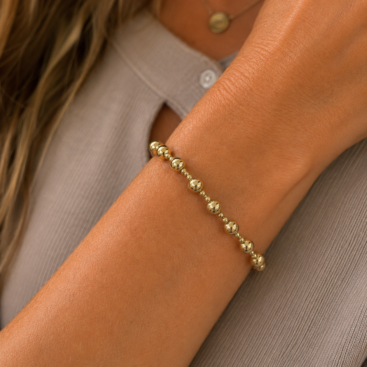 Stretch beaded stackable gold bracelet with small and larger beads– steel 18 karat gold overlay