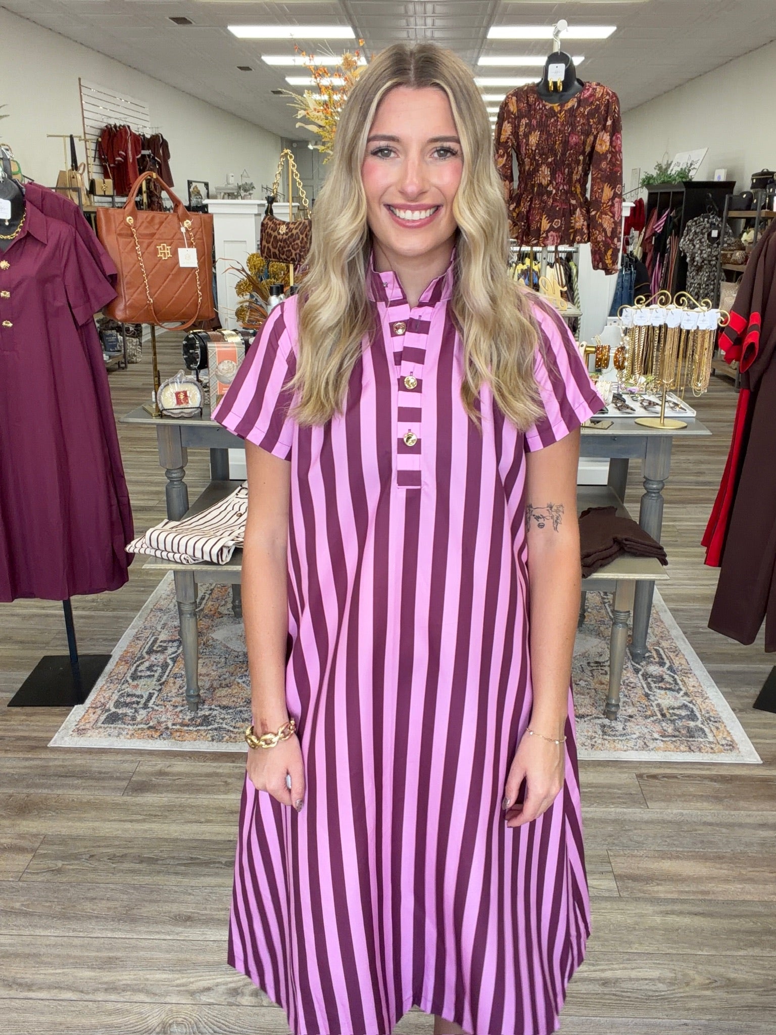 Raspberry Rush Dress – bold pink and burgundy striped dress featuring a relaxed silhouette, collared neckline, and chic gold button detailing.