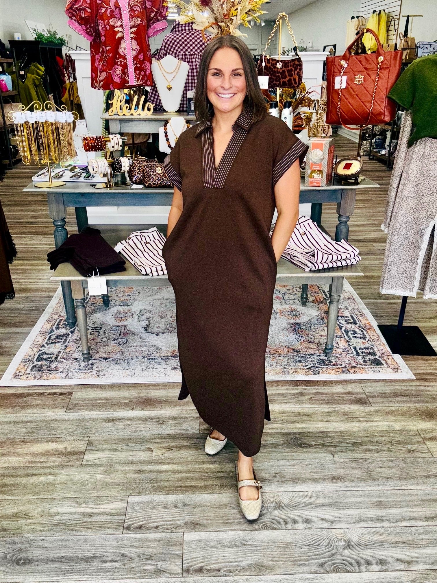 The espresso dress - relaxed straight silhouette featuring pockets, short cuffed sleeves, a split V-neck polo collar, and contrasting white topstitching on the collar, placket, and sleeve cuffs