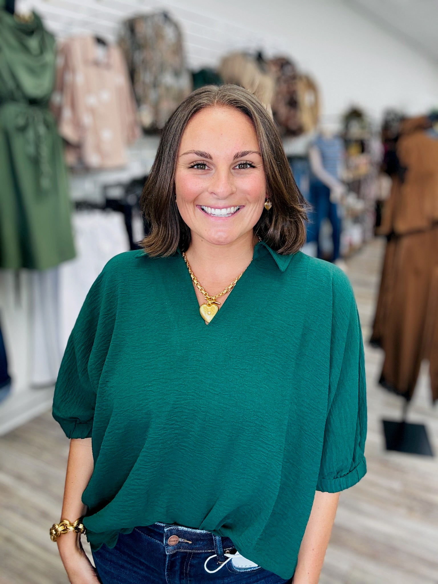 The Harper Top -a hunter green  relaxed oversized blouse infeaturing a split V-neck collar, flowy short sleeves, and a scalloped bottom hem