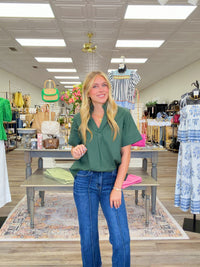 The Scarlett blouse - a rich green blouse featuring a pleated stand collar, short sleeves with stitched cuff details.
