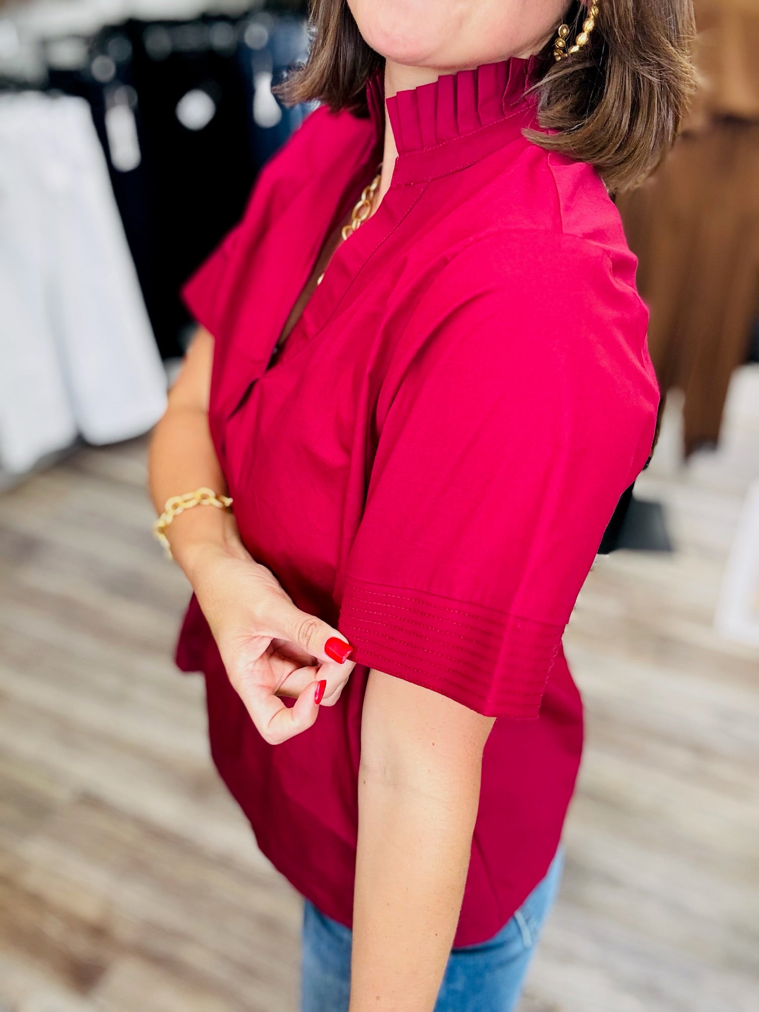 The Scarlett blouse - a rich berry-red blouse featuring a pleated stand collar, short sleeves with stitched cuff details.