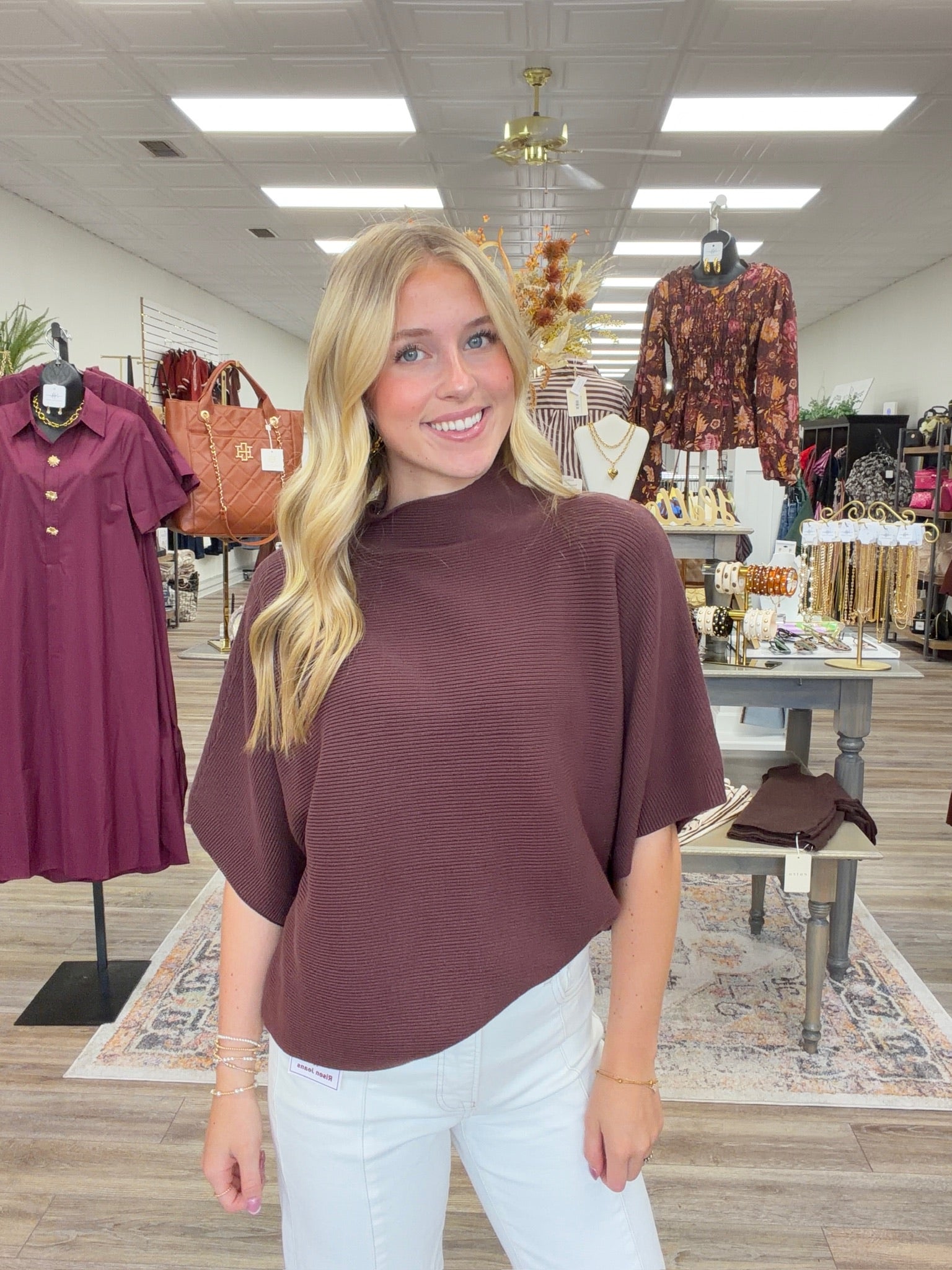 The Nora sweater-  A brown ribbed-knit mock-neck top featuring a relaxed oversized silhouette, wide elbow-length sleeves Entro