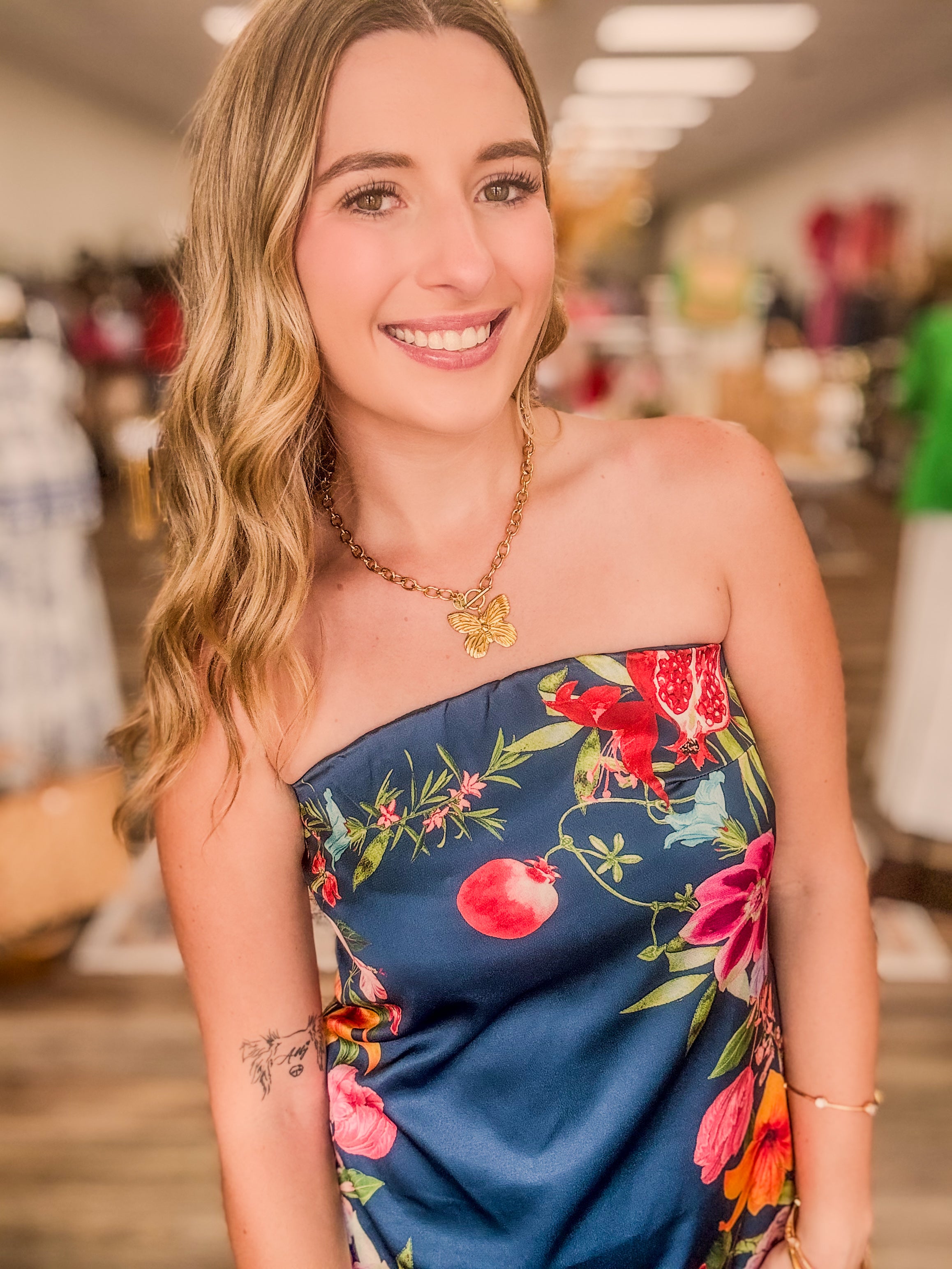 The  Valencia floral dress - A strapless navy-blue satin midi dress featuring a fitted bodice that flows into a softly flared skirt.
