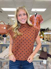 The cinnamon Spice Dot Sweater top features structured cap sleeves, navy polka dot pattern and a relaxed fit.