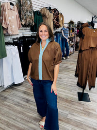 The Sienna top - Chocolate brown top with light blue contrast trim, a split neckline, and puff sleeves.