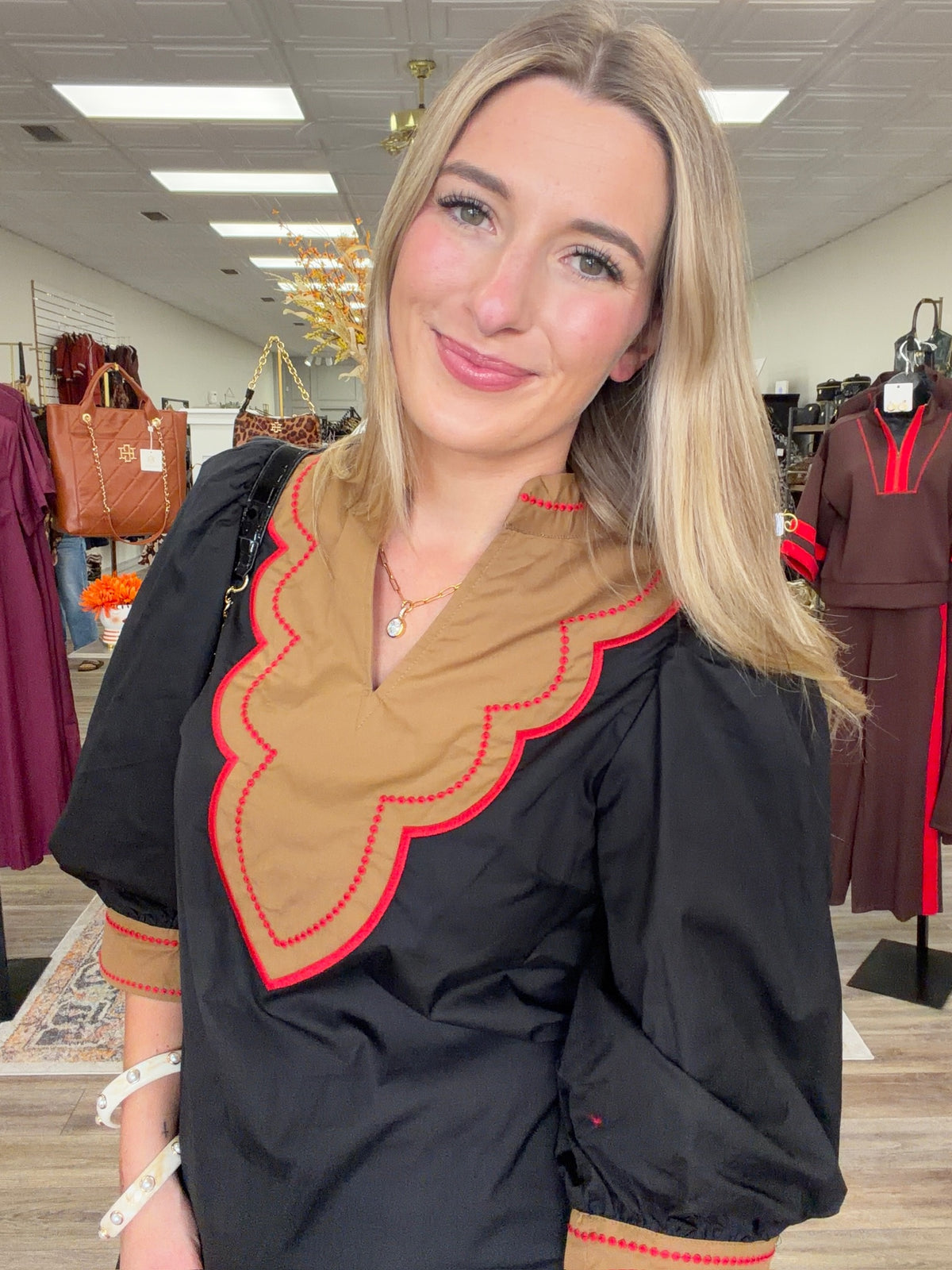 Saddle & Scarlet Blouse - chic black puff-sleeve top featuring a camel scalloped bib collar with vibrant red embroidered trim and matching statement cuffs