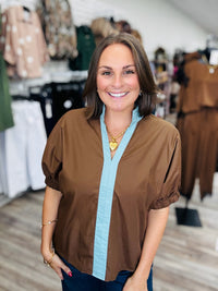 The Sienna top - Chocolate brown top with light blue contrast trim, a split neckline, and puff sleeves.
