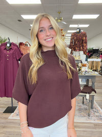 The Nora sweater-  A brown ribbed-knit mock-neck top featuring a relaxed oversized silhouette, wide elbow-length sleeves Entro