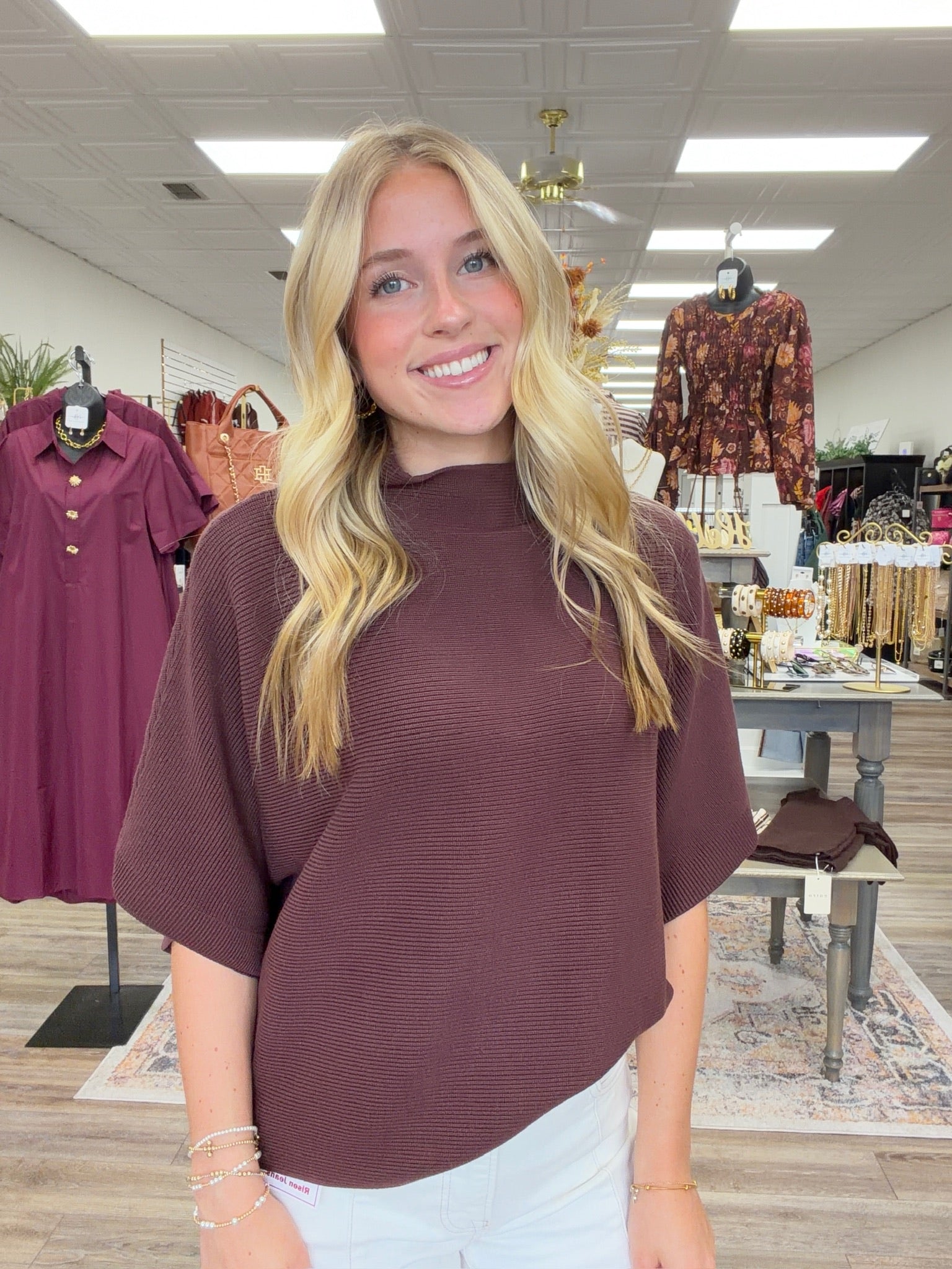 The Nora sweater-  A brown ribbed-knit mock-neck top featuring a relaxed oversized silhouette, wide elbow-length sleeves Entro