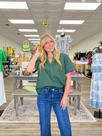 The Scarlett blouse - a rich green blouse featuring a pleated stand collar, short sleeves with stitched cuff details.