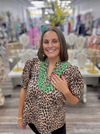 The Evangeline blouse - leopard print blouse featuring a V-neckline with bright green embroidery trim, puff sleeves, and a flowy silhouette. Entro style#T31886