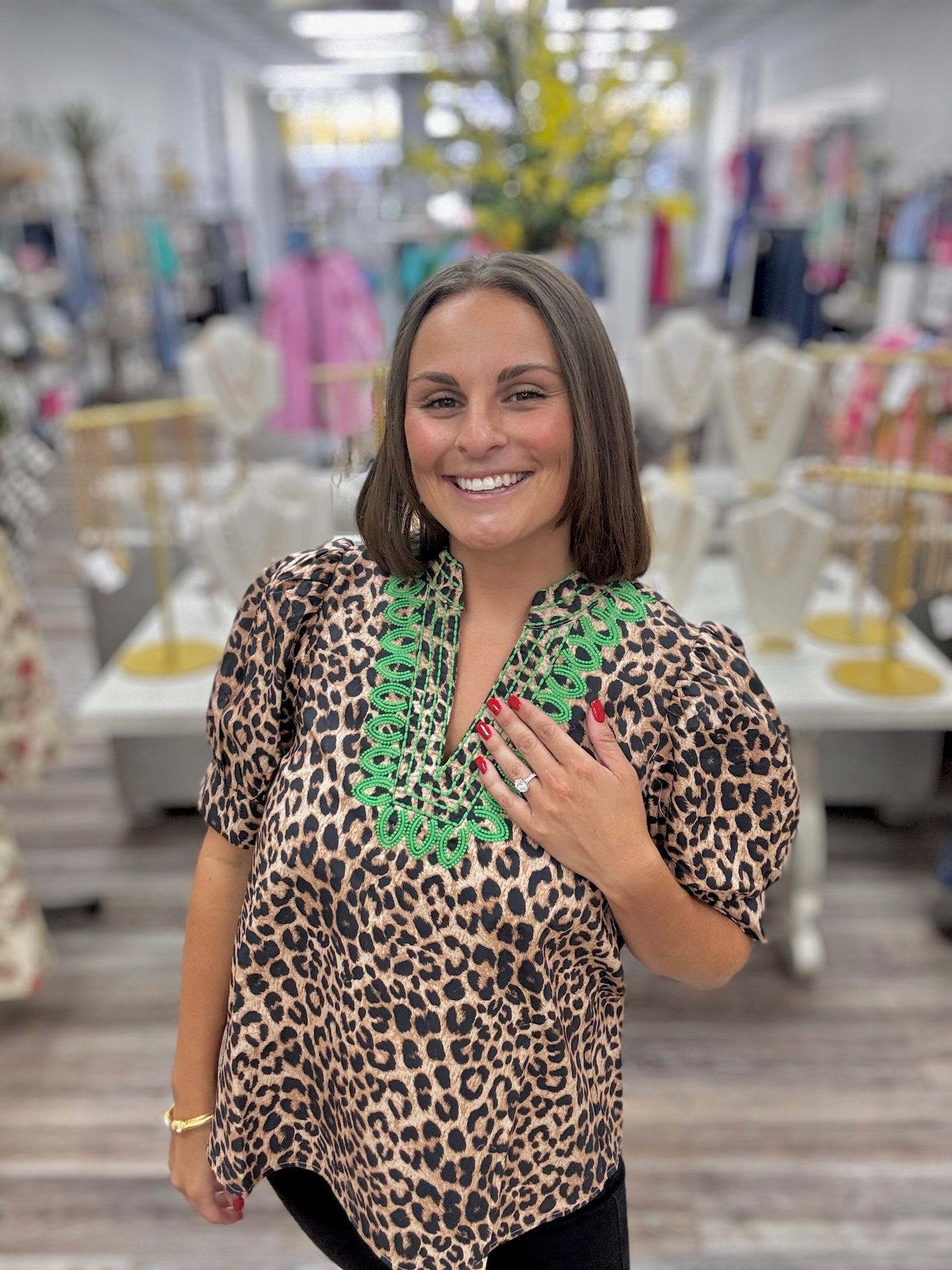 The Evangeline blouse - leopard print blouse featuring a V-neckline with bright green embroidery trim, puff sleeves, and a flowy silhouette. Entro style#T31886