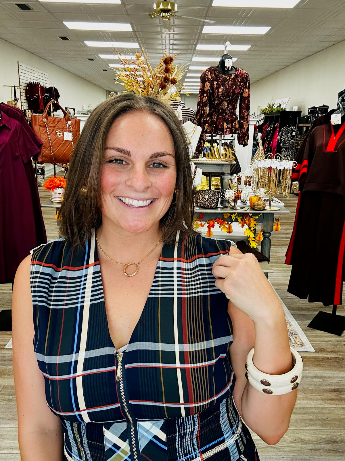 The Denise dress - navy plaid midi dress featuring a flattering smocked waist, sleeveless silhouette, and a bold mix of autumn-inspired colors.