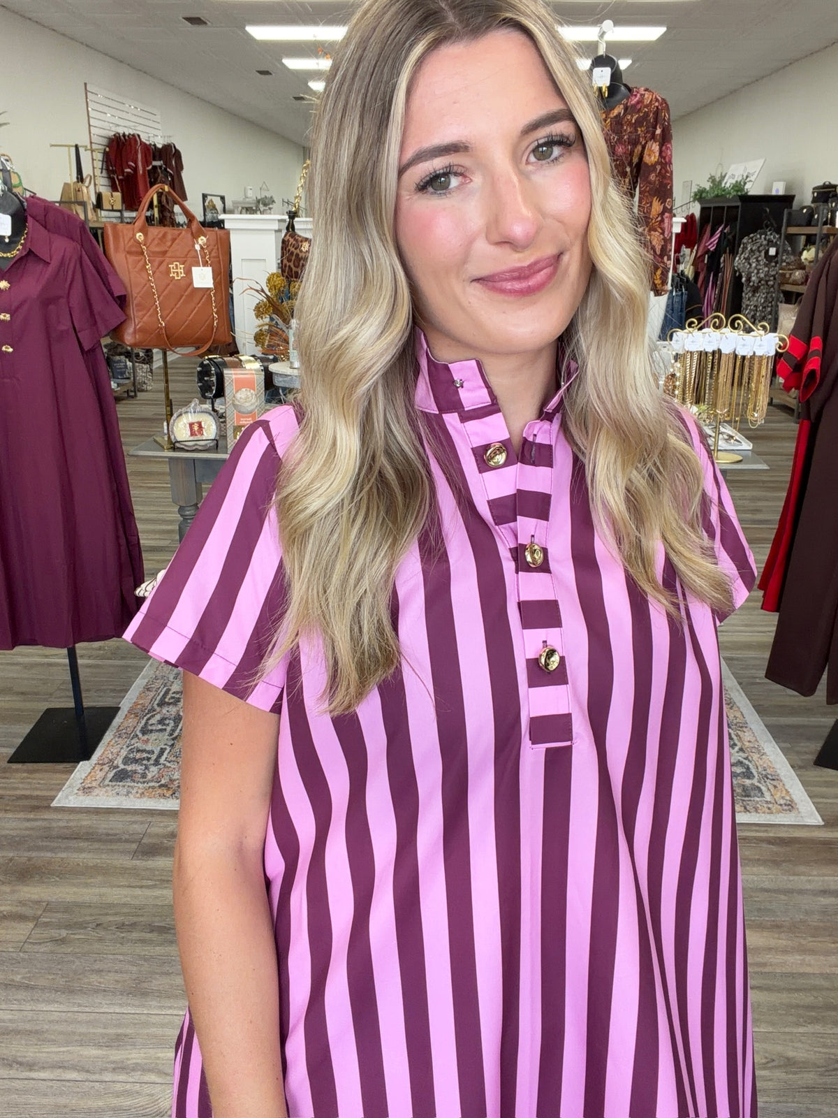 Raspberry Rush Dress – bold pink and burgundy striped dress featuring a relaxed silhouette, collared neckline, and chic gold button detailing.