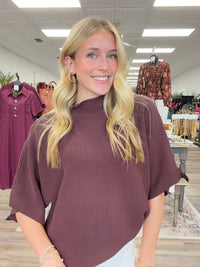 The Nora sweater-  A brown ribbed-knit mock-neck top featuring a relaxed oversized silhouette, wide elbow-length sleeves Entro