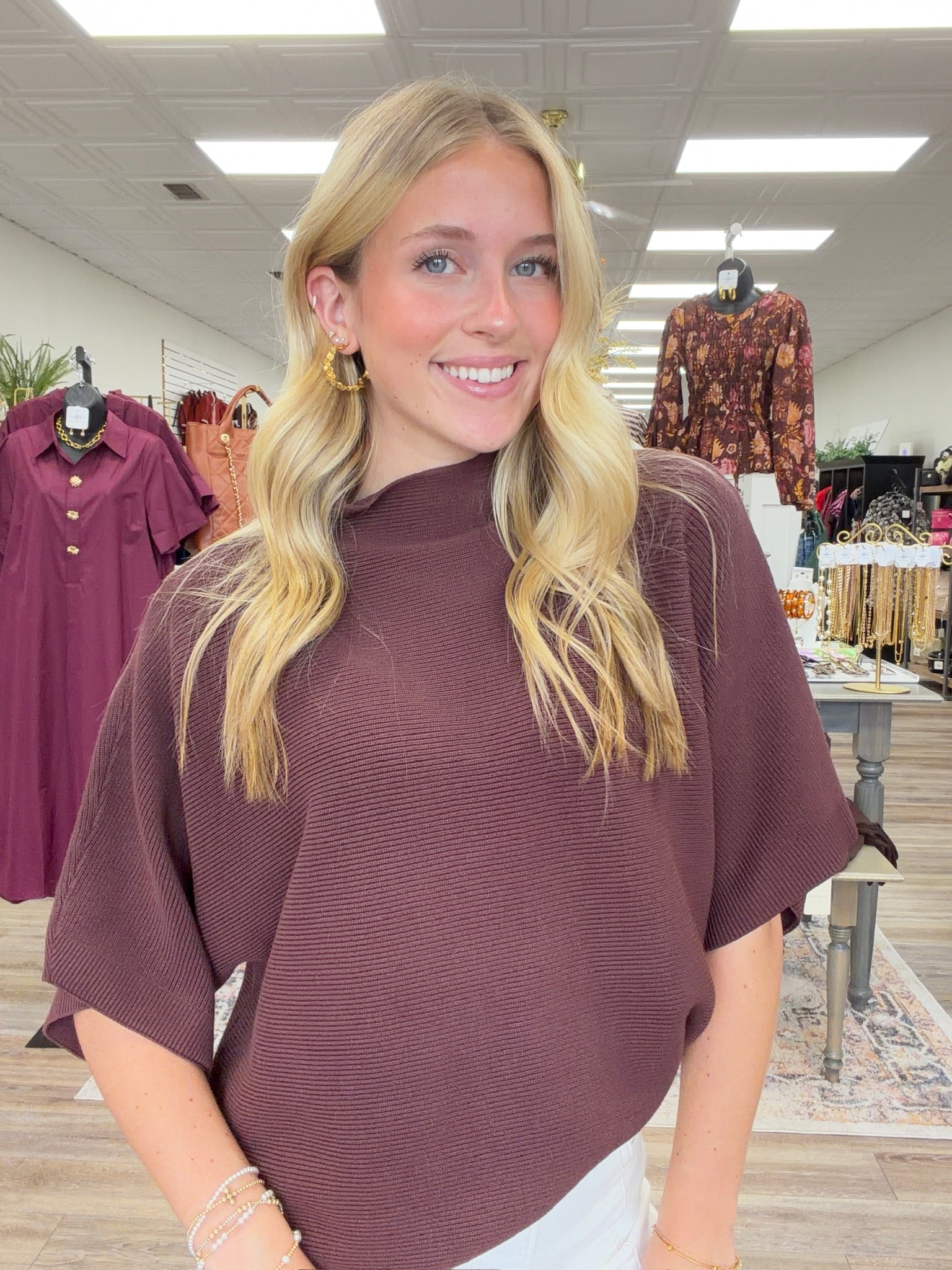 The Nora sweater-  A brown ribbed-knit mock-neck top featuring a relaxed oversized silhouette, wide elbow-length sleeves Entro
