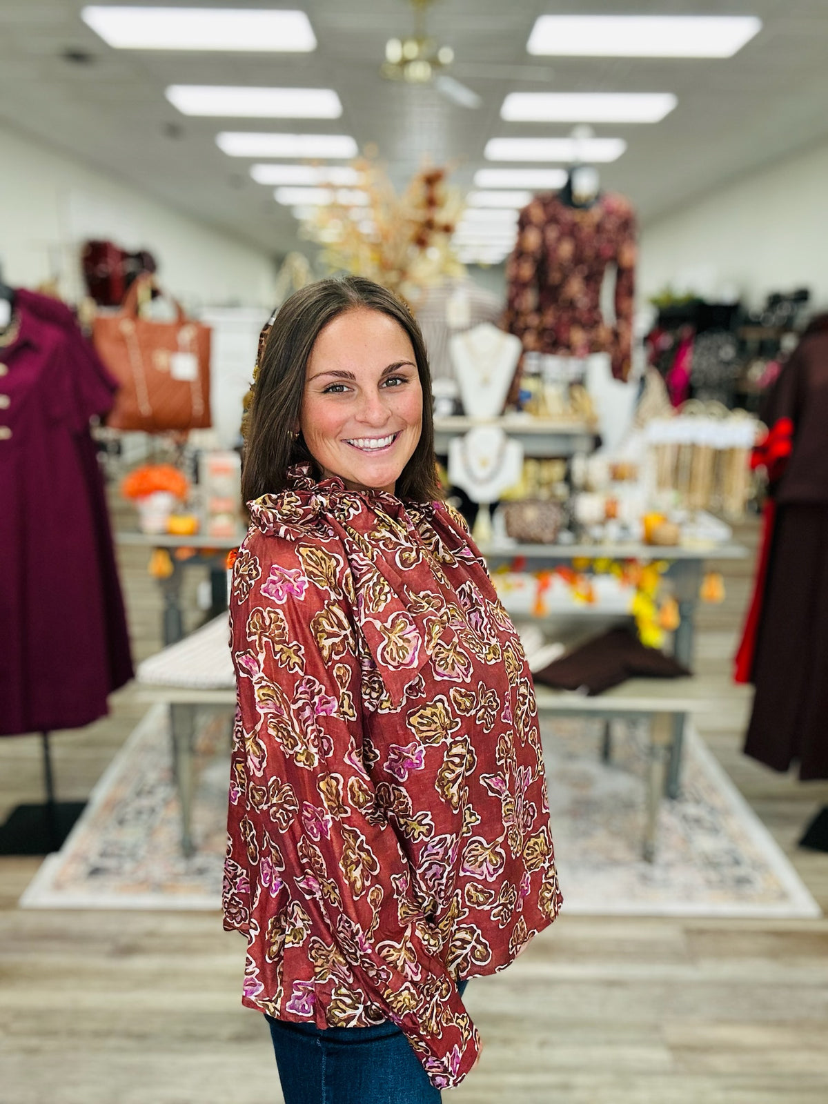 Autumn Romance Blouse- Brick colored blouse with fall floral print, featuring a tie neckline and thin long sleeves.