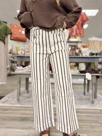 The portside pant - Cream cropped pants with thin brown stripes, a high-rise fit, and oversized button-detail front pockets