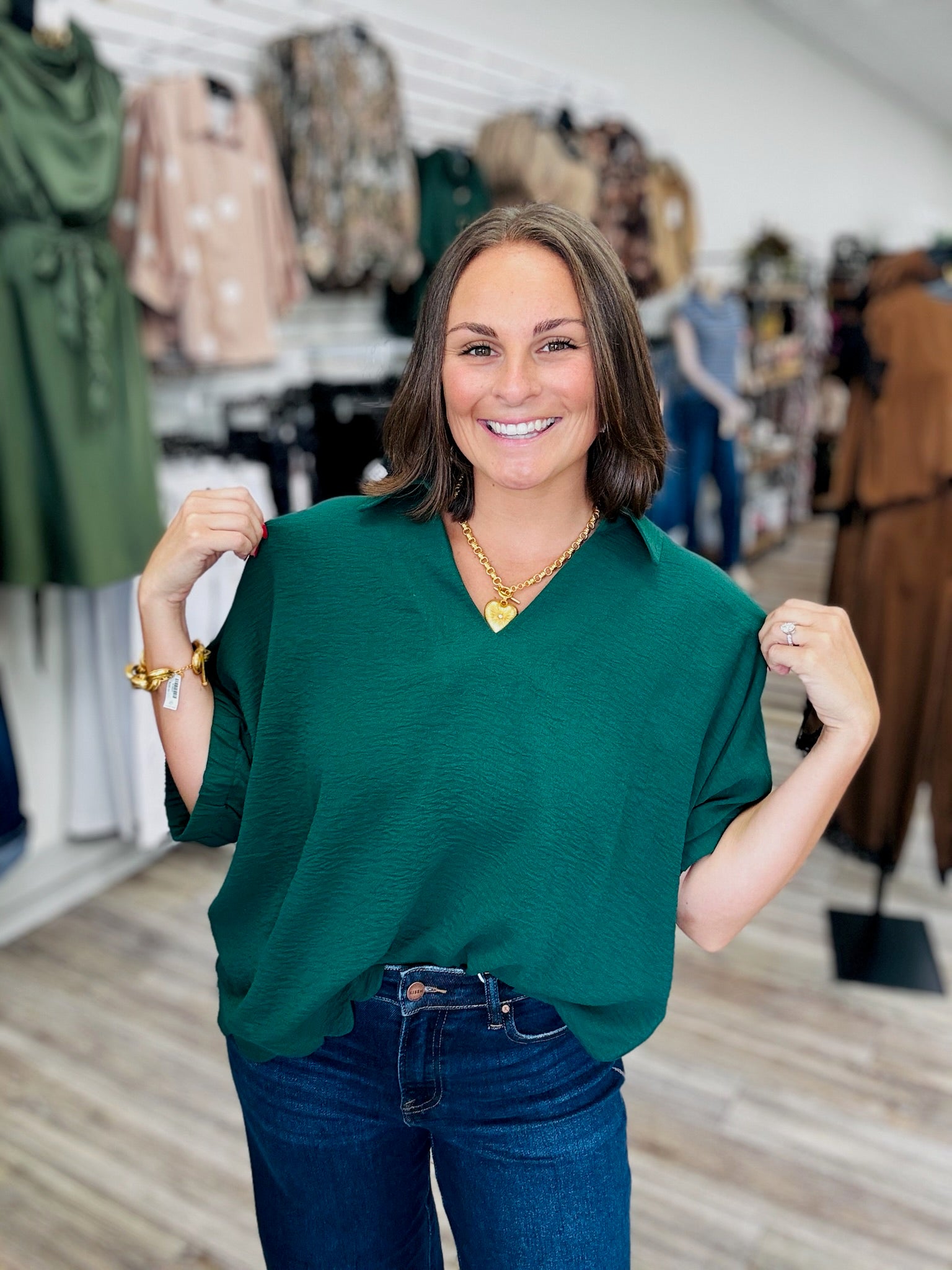 The Harper Top -a hunter green  relaxed oversized blouse infeaturing a split V-neck collar, flowy short sleeves, and a scalloped bottom hem