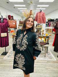 The Savannah Luxe Leopard Embroidered Tunic features a classic black fabric with leopard- inspired embroidered detailing. Ruffled mock neckline and three- quarter puff sleeves.