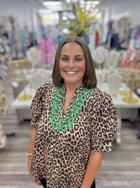 The Evangeline blouse - leopard print blouse featuring a V-neckline with bright green embroidery trim, puff sleeves, and a flowy silhouette. Entro style#T31886