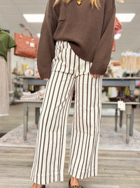 The portside pant - Cream cropped pants with thin brown stripes, a high-rise fit, and oversized button-detail front pockets