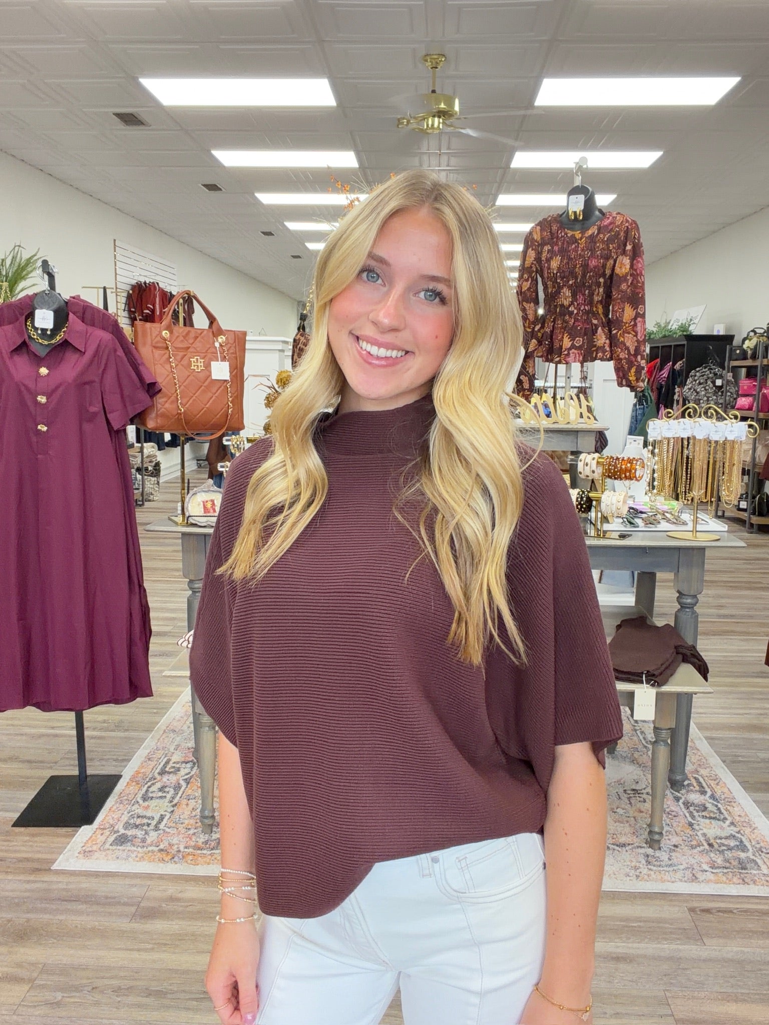 The Nora sweater-  A brown ribbed-knit mock-neck top featuring a relaxed oversized silhouette, wide elbow-length sleeves Entro