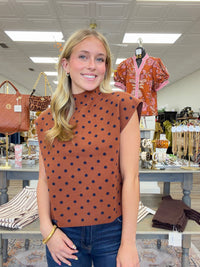 The cinnamon Spice Dot Sweater top features structured cap sleeves, navy polka dot pattern and a relaxed fit.