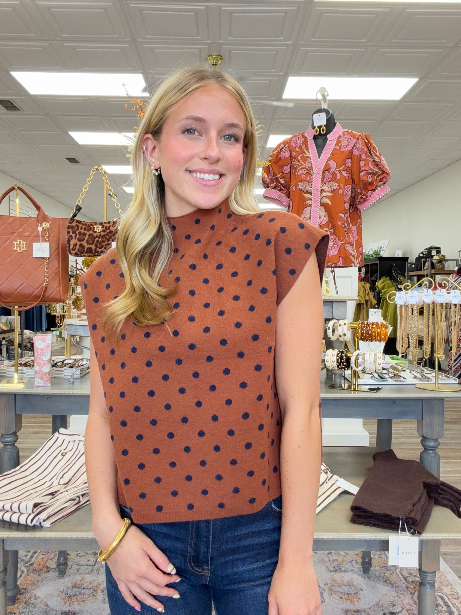 The cinnamon Spice Dot Sweater top features structured cap sleeves, navy polka dot pattern and a relaxed fit.