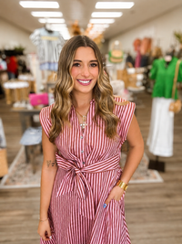 The Rosy Stroll Striped Shirt Dress. This dress features a lightweight woven fabric, collared neckline, short cap sleeves and a adjustable self-tie waist-Entro